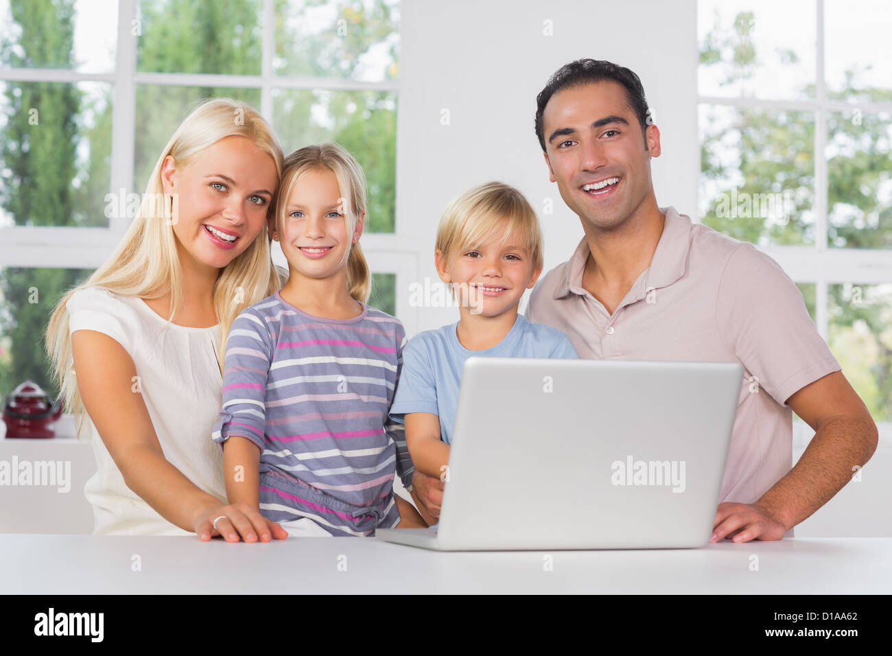Happy family using a laptop together Stock Photo - Alamy