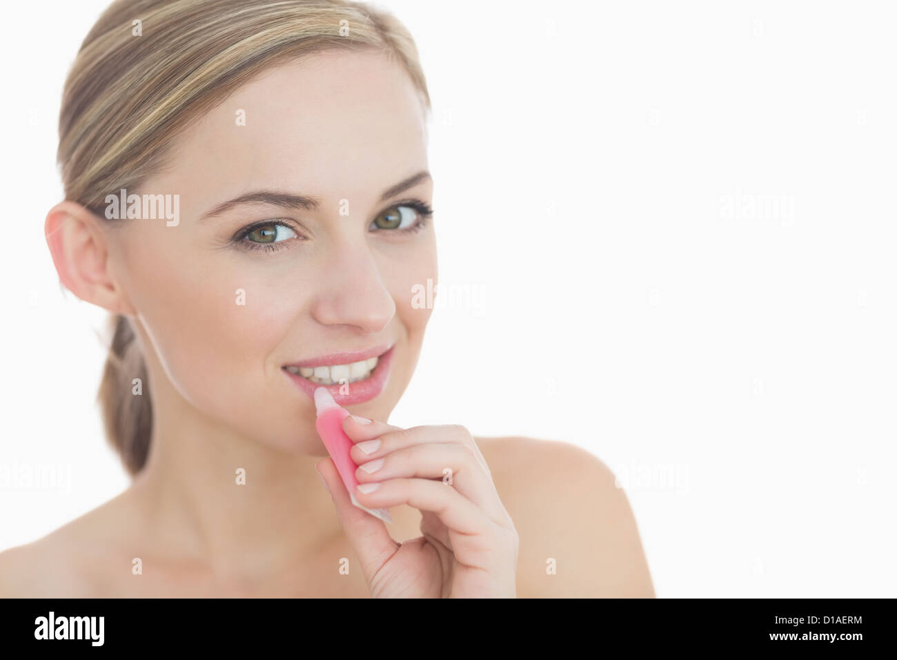 Close-up portrait of young woman applying lipgloss Stock Photo