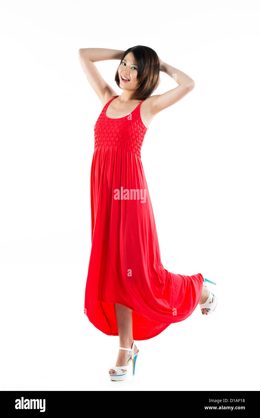 Happy Chinese woman wearing red summer dress. Energetic full length portrait of a young beautiful woman. isolated on white backg Stock Photo