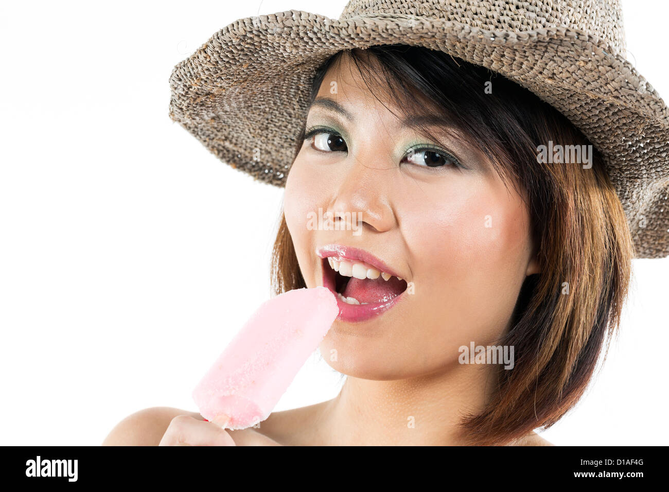 Chinese woman eating an ice lolly. Isolated on white. Stock Photo