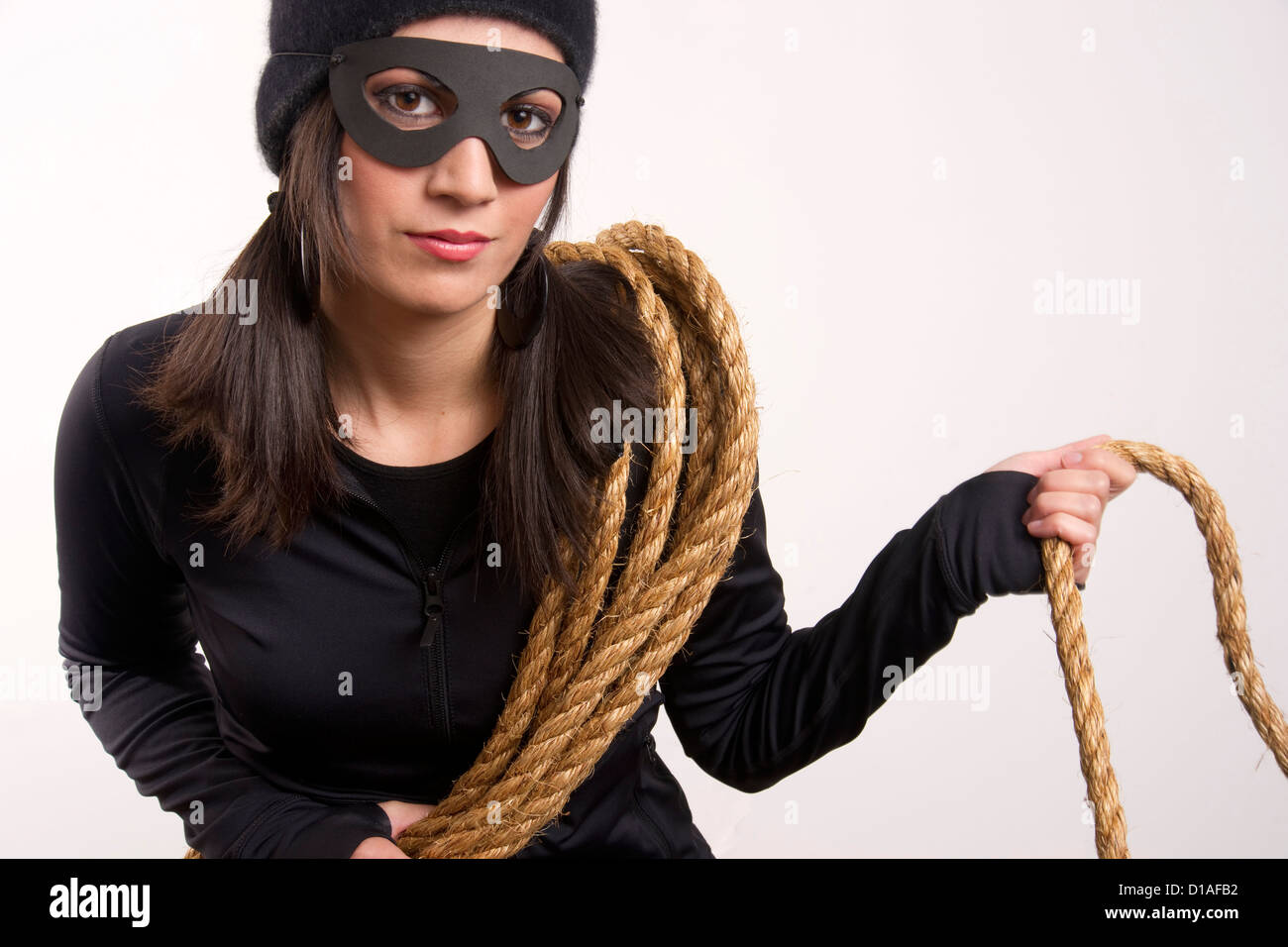 A thief lurks around the house after using a rope to gain entry upstairs Stock Photo