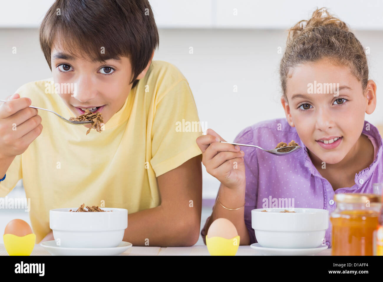 Happy siblings having breakfast Stock Photo - Alamy