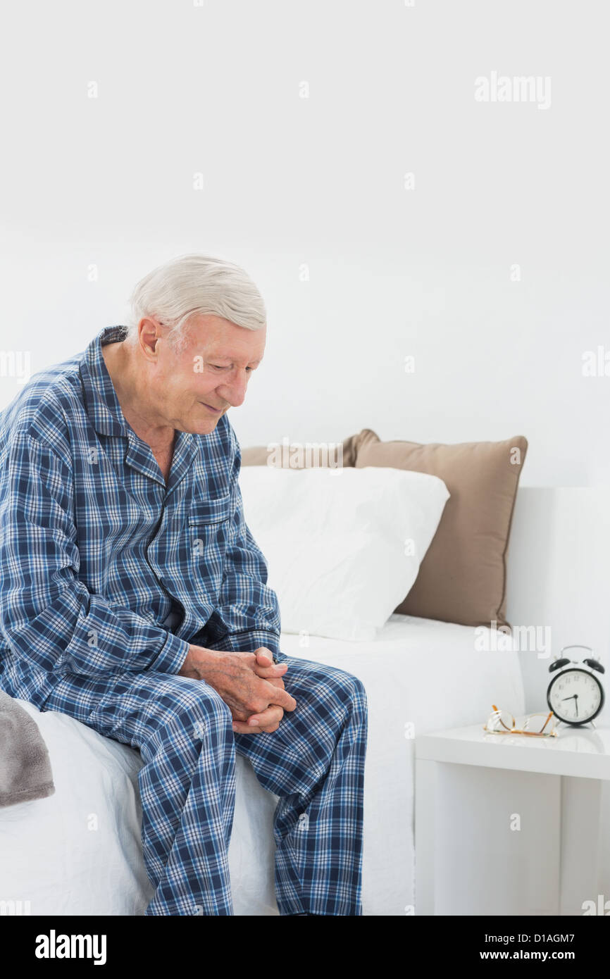 Calm elderly man sitting on the bed Stock Photo Alamy