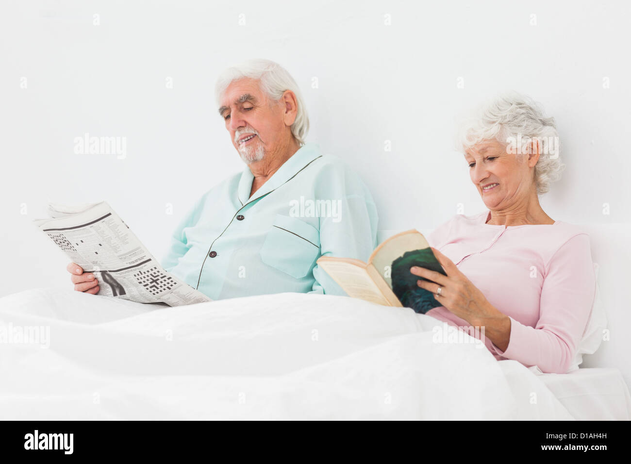 Smiling couple reading in bed Stock Photo Alamy