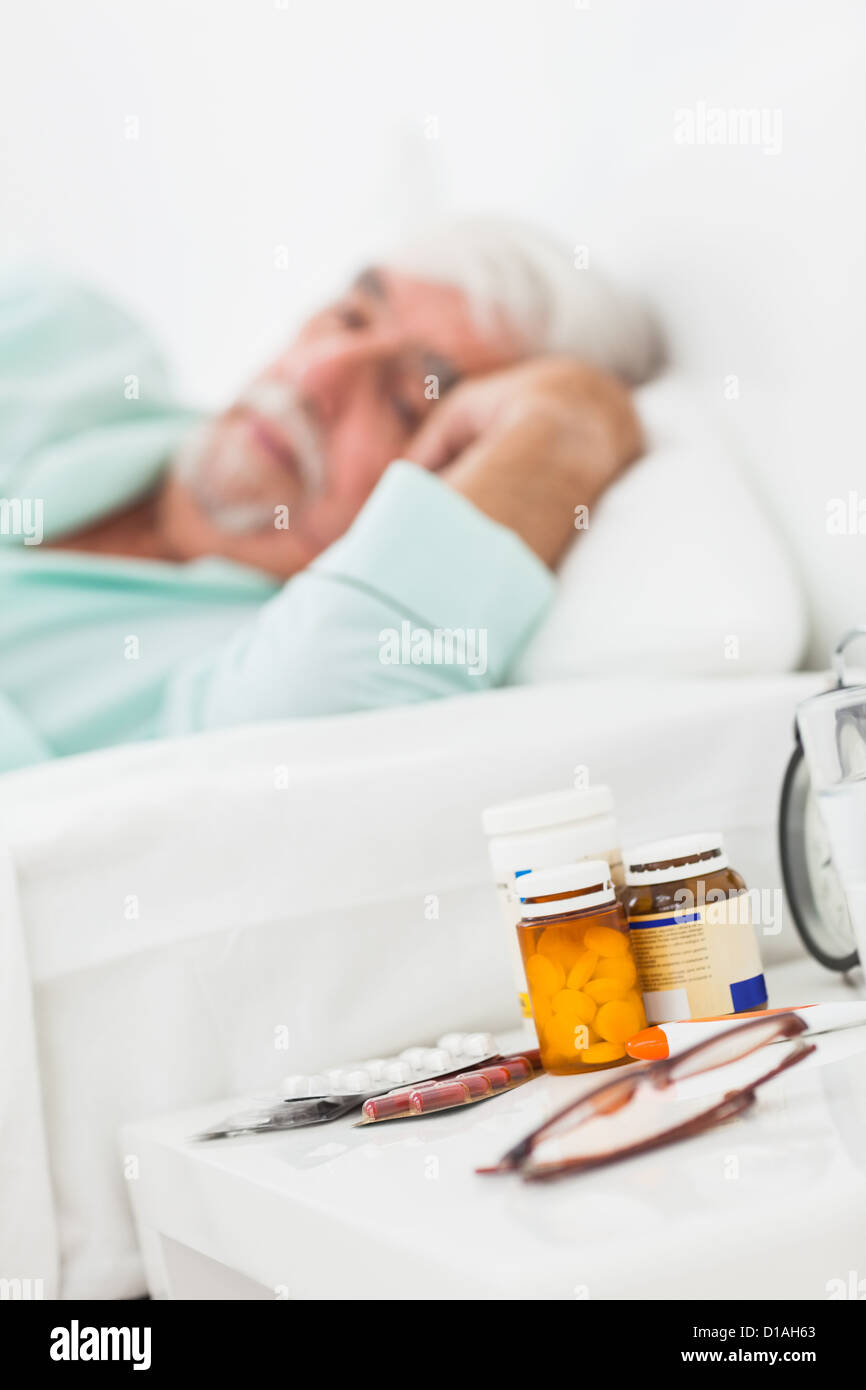 Bedside table with pills and glasses Stock Photo
