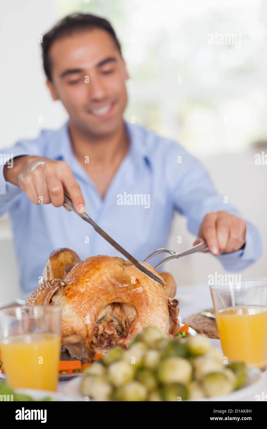 Man carving turkey at head of table Stock Photo Alamy