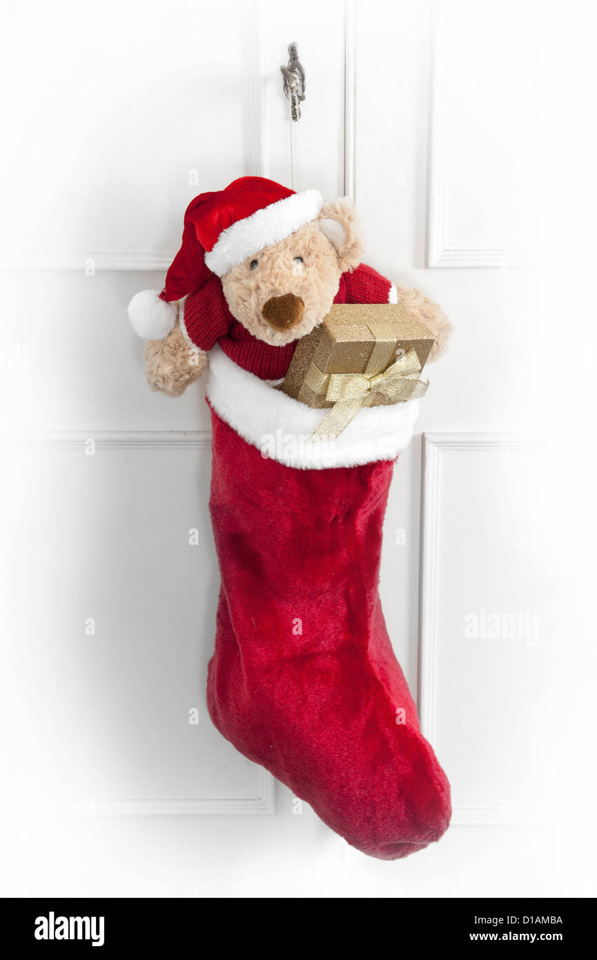Christmas Sock With Teddy Bear And Gifts Hanging On A Door Stock