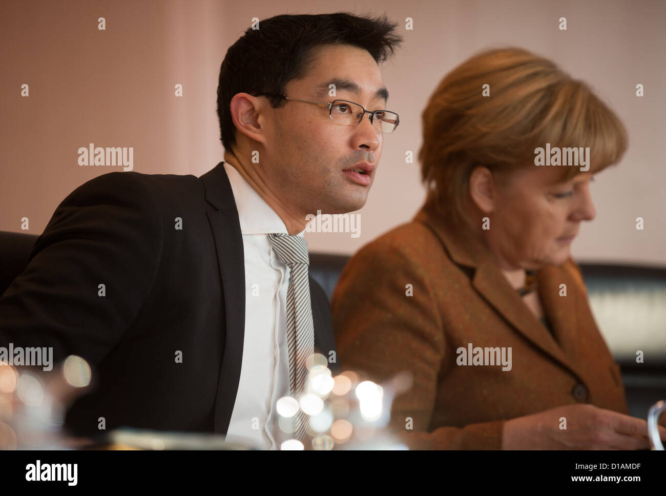 German Federal Chancellor Angela Merkel (R, CDU) and German Minister of Economics Philipp Roesler (FDP) talk during the meeting of the Federal Cabinet at the Federal Chancellery in Berlin, Germany, 12 December 2012. The Federal Cabinet discusses the budget of the Federal Agency of Employment in 2013 and the reform of central index of traffic offenders. Photo: Michael Kappeler Stock Photo