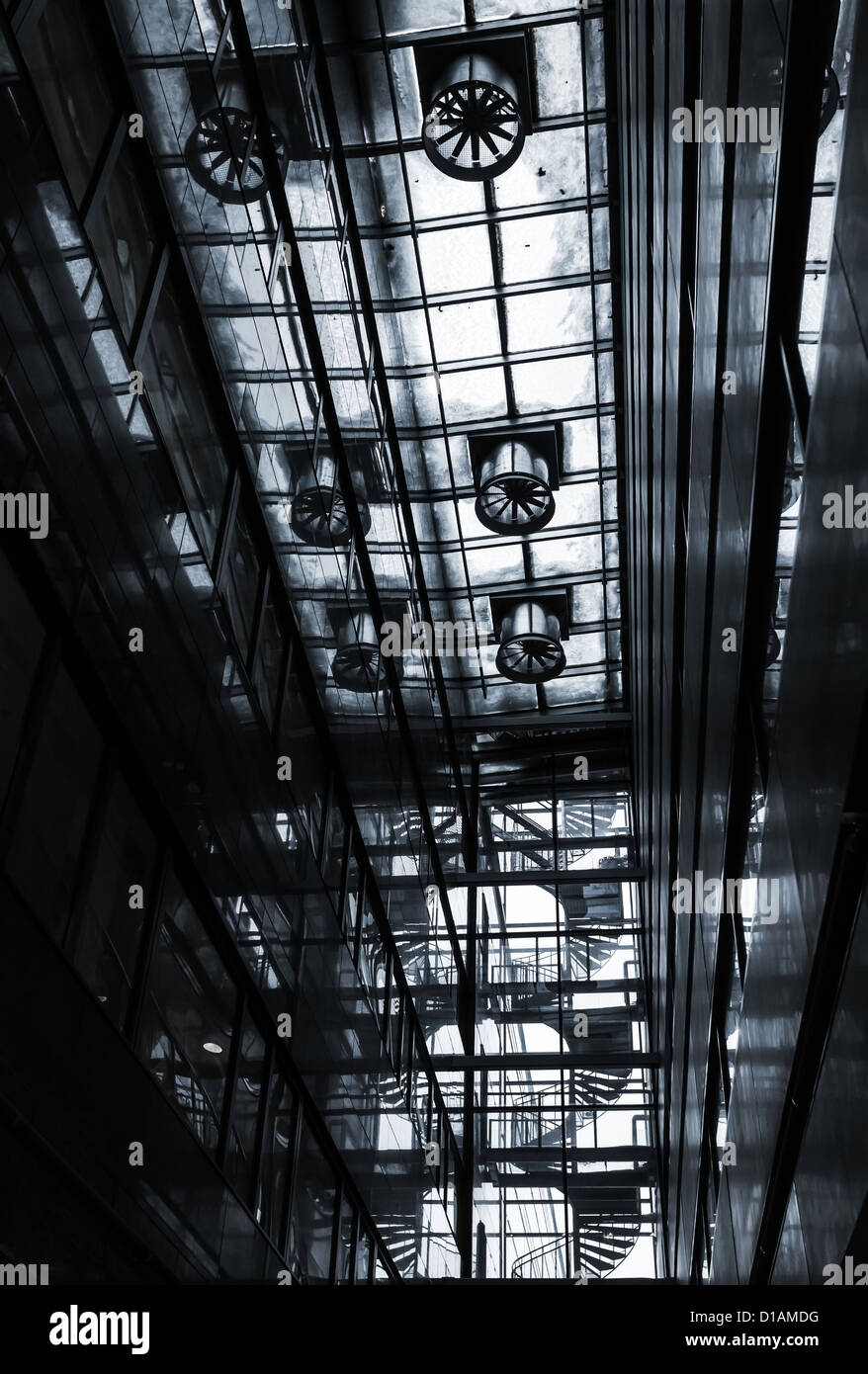 Dark abstract industrial interior with transparent ceiling, ventilation and spiral stairs Stock Photo