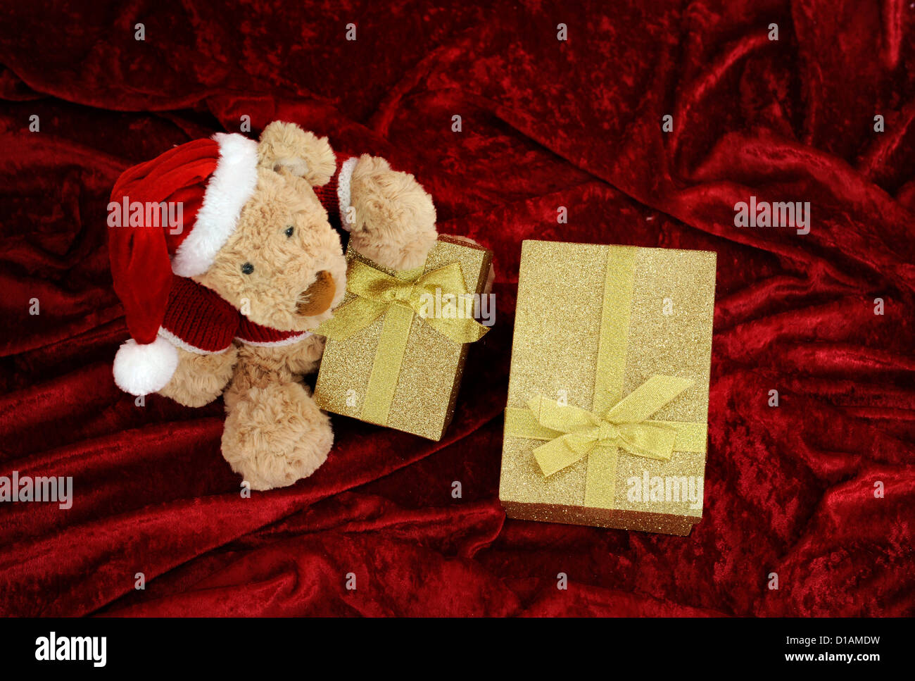 Teddy bear with golden gift box on red background Stock Photo - Alamy