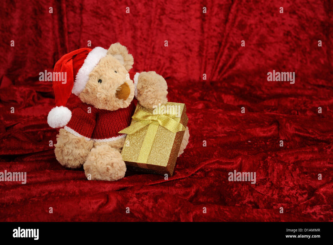 Teddy bear with golden gift box on red background Stock Photo - Alamy