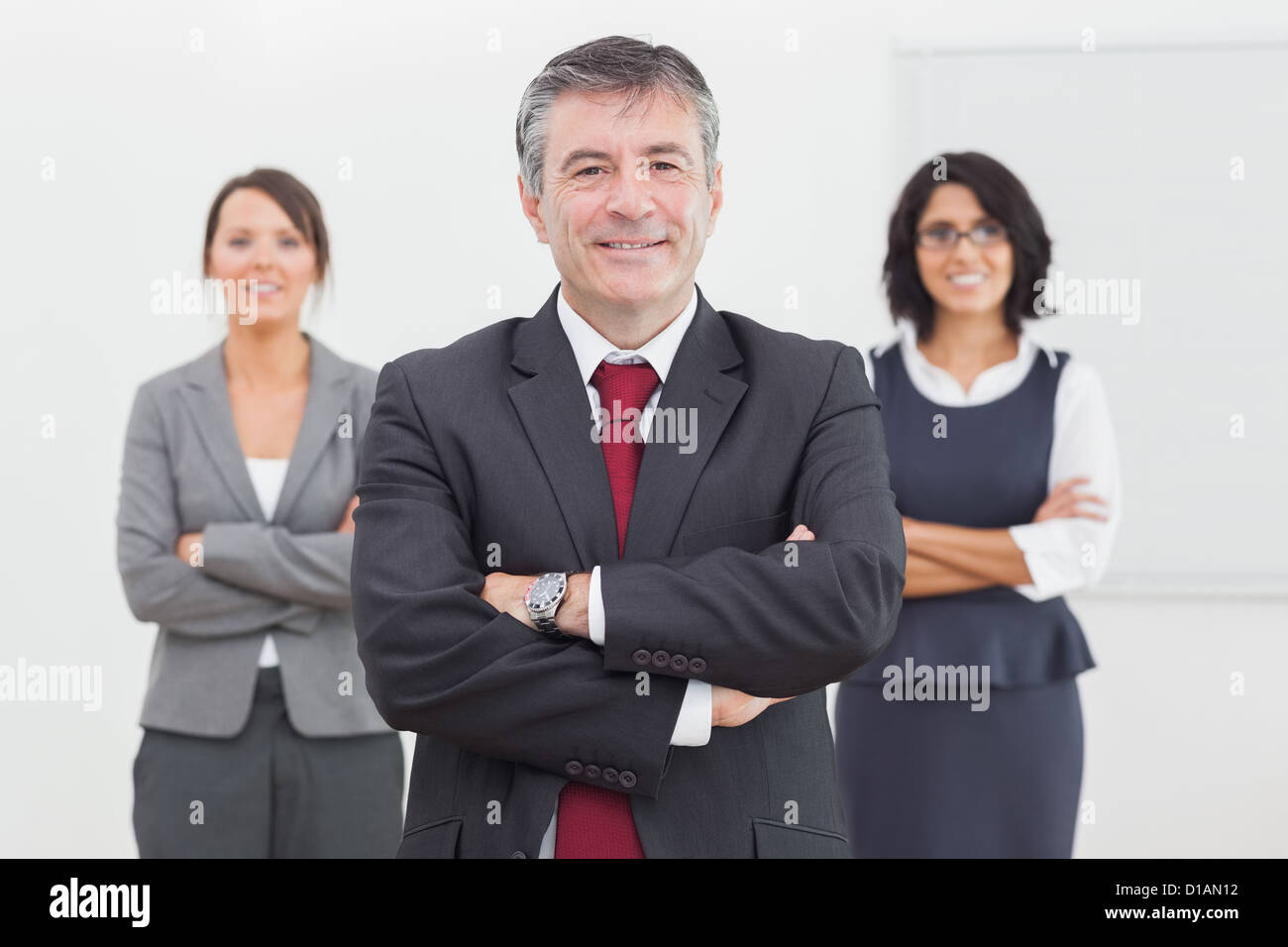 Businessman and his team smiling standing Stock Photo - Alamy
