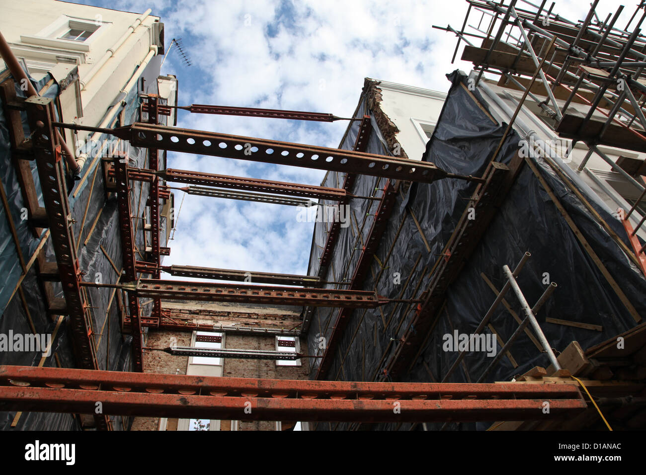 Struts to support buildings on opposite sides of a house that has been