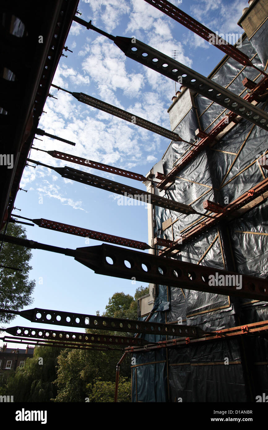 Struts to support buildings on opposite sides of a house that has been demolished for a new build. Stock Photo