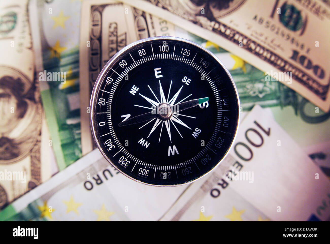Compass with american and european money Stock Photo