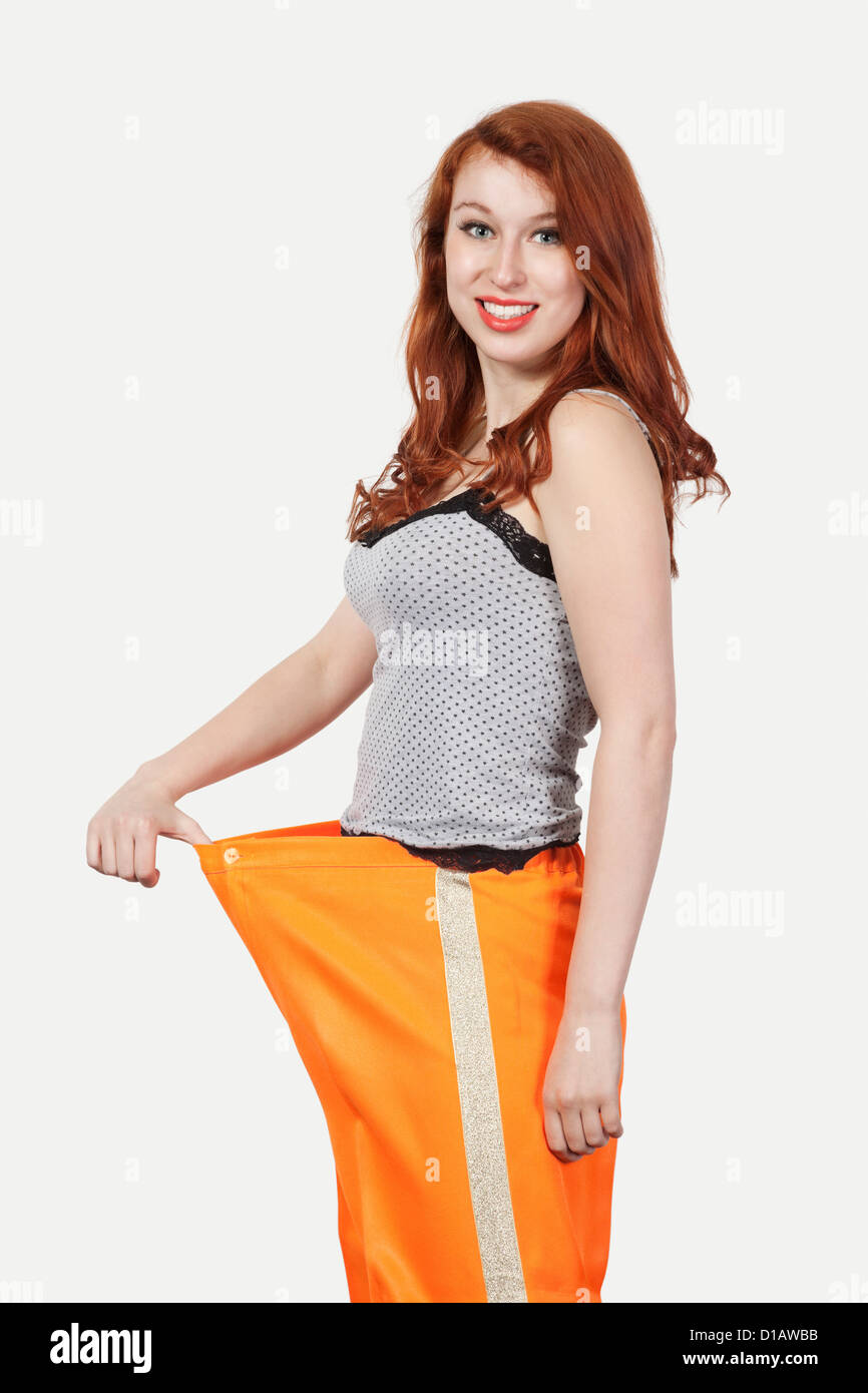 Portrait young Caucasian woman oversized orange pants Stock Photo