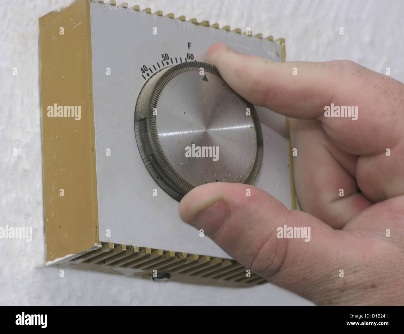 Energy efficiency man lowering the thermostat on the central heating
