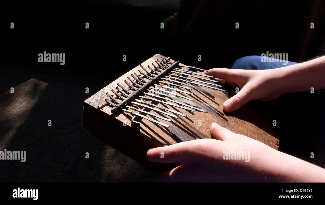 Young boy playing mbira thumb piano Stock Photo Alamy