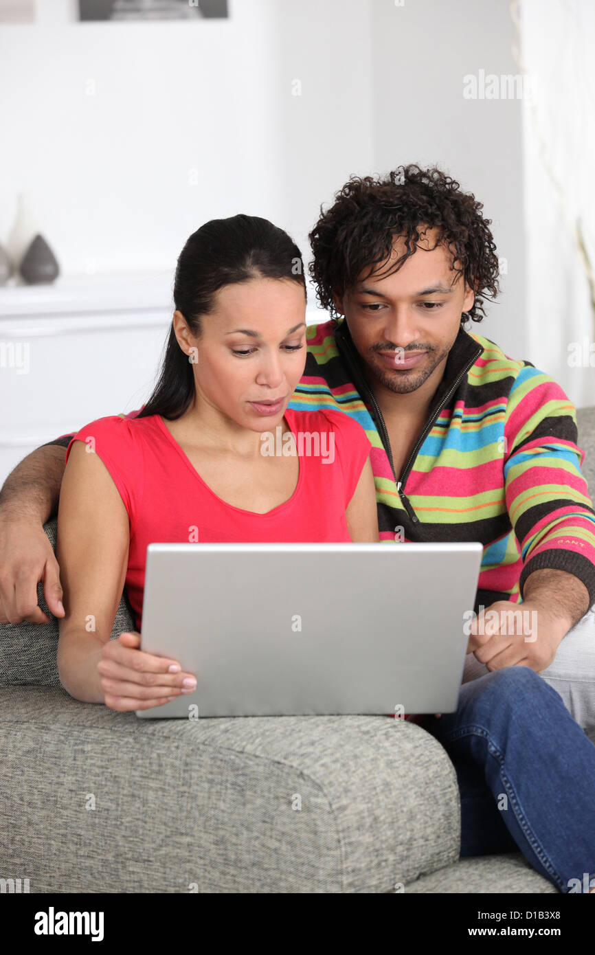 Couple at home looking at a laptop Stock Photo - Alamy