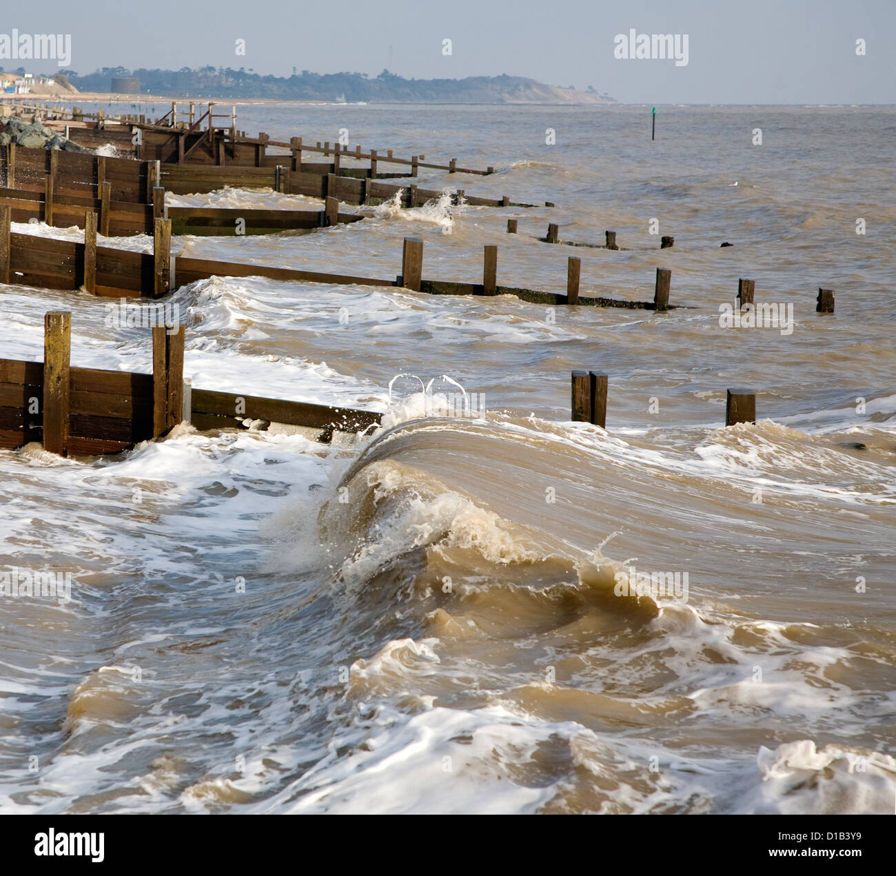 Waves wooden groynes sea defences Cobbold's Point, Felixstowe, Suffolk, England Stock Photo