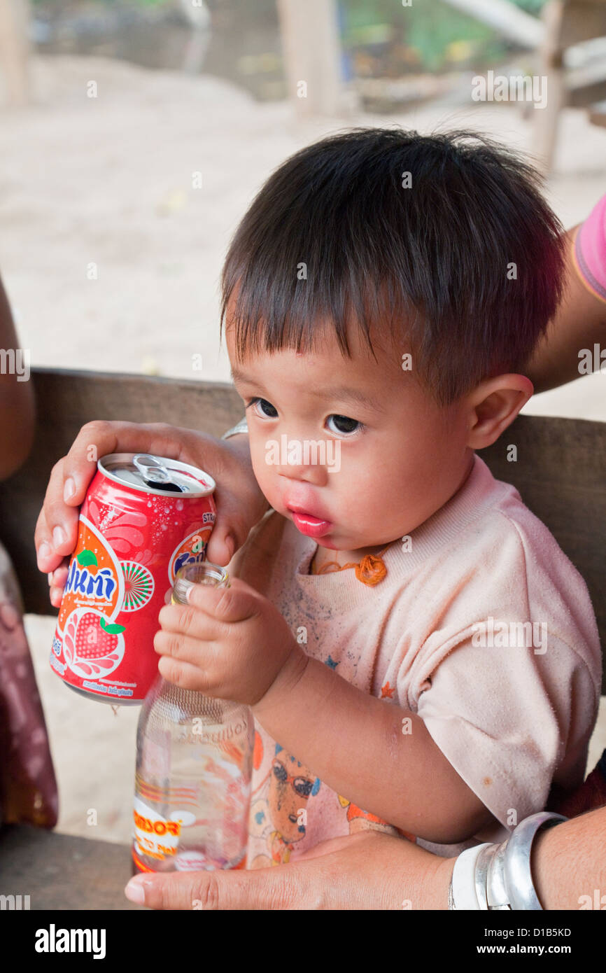 Young boy from the Kayan minority group drinking bright red drink, Huai Seau Tao, Mae Hong Son Province, Thailand Stock Photo