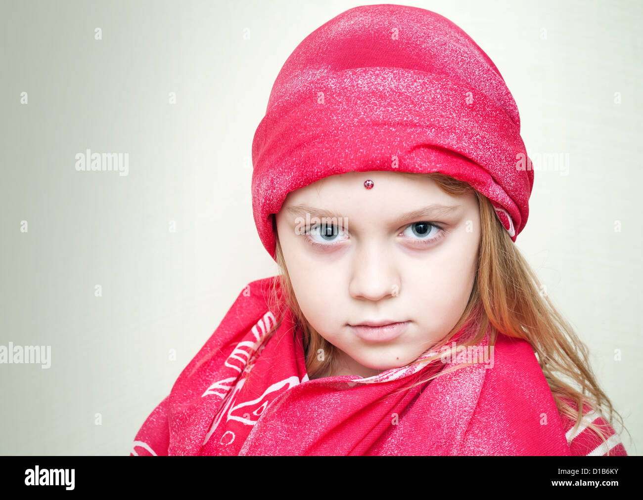 Closeup portrait of little beautiful blond girl in red eastern Clothing Stock Photo