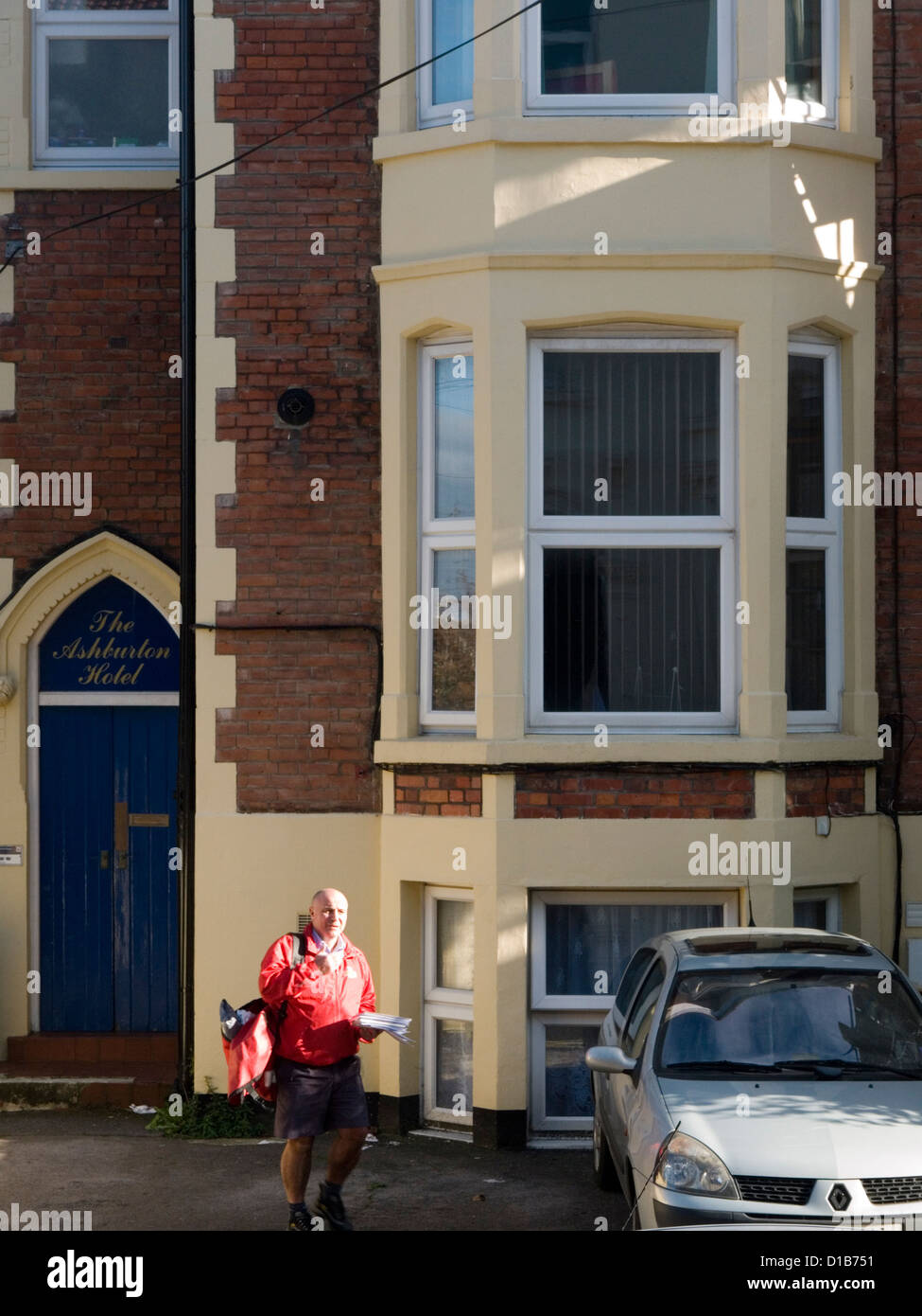 postman on his rounds in bright sunshine Stock Photo