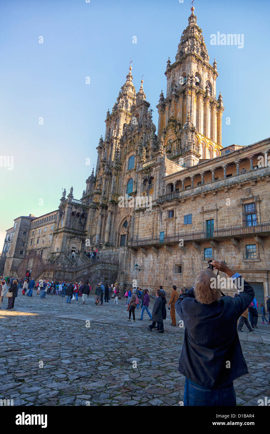 Man standing in the Plaza El Obradoiro taking a picture of the Santiago Cathedral. One of the many pilgrims in the square Stock Photo