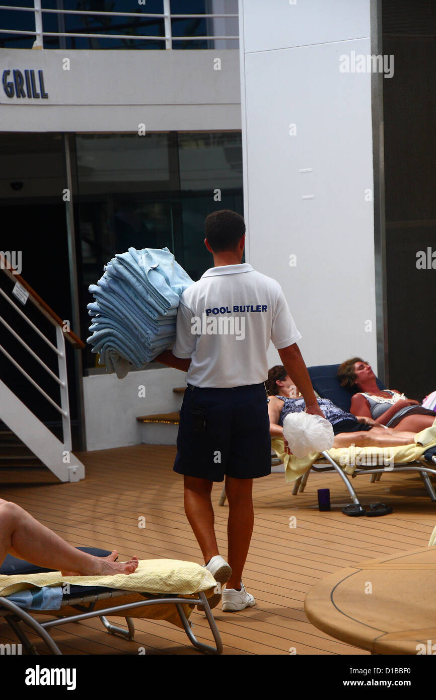 A pool butler on a cruise ship pool deck carrying clean towels Stock
