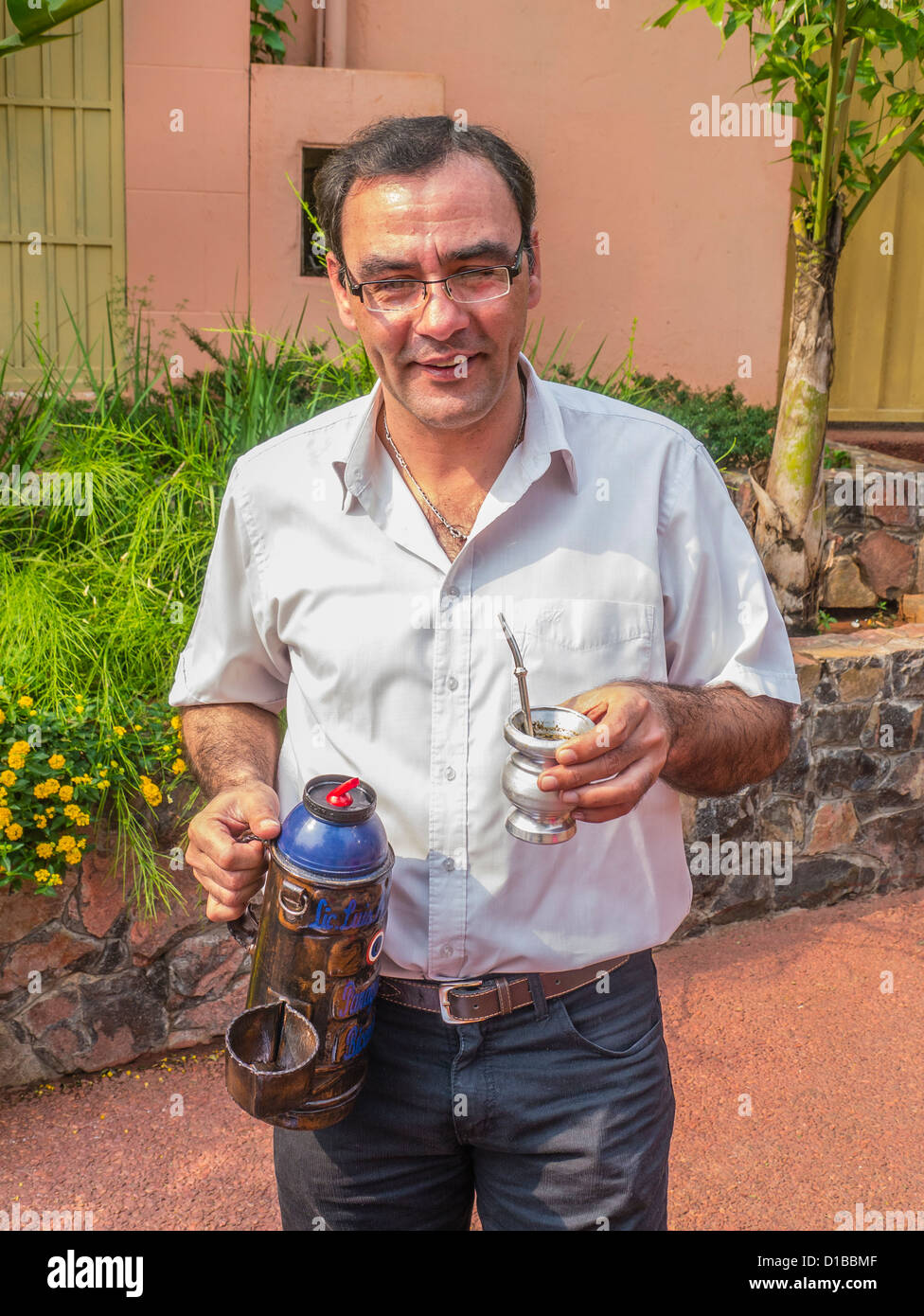 A male Paraguayan secondary school teacher takes a break and holds a cup of tereré with the metal straw. Stock Photo
