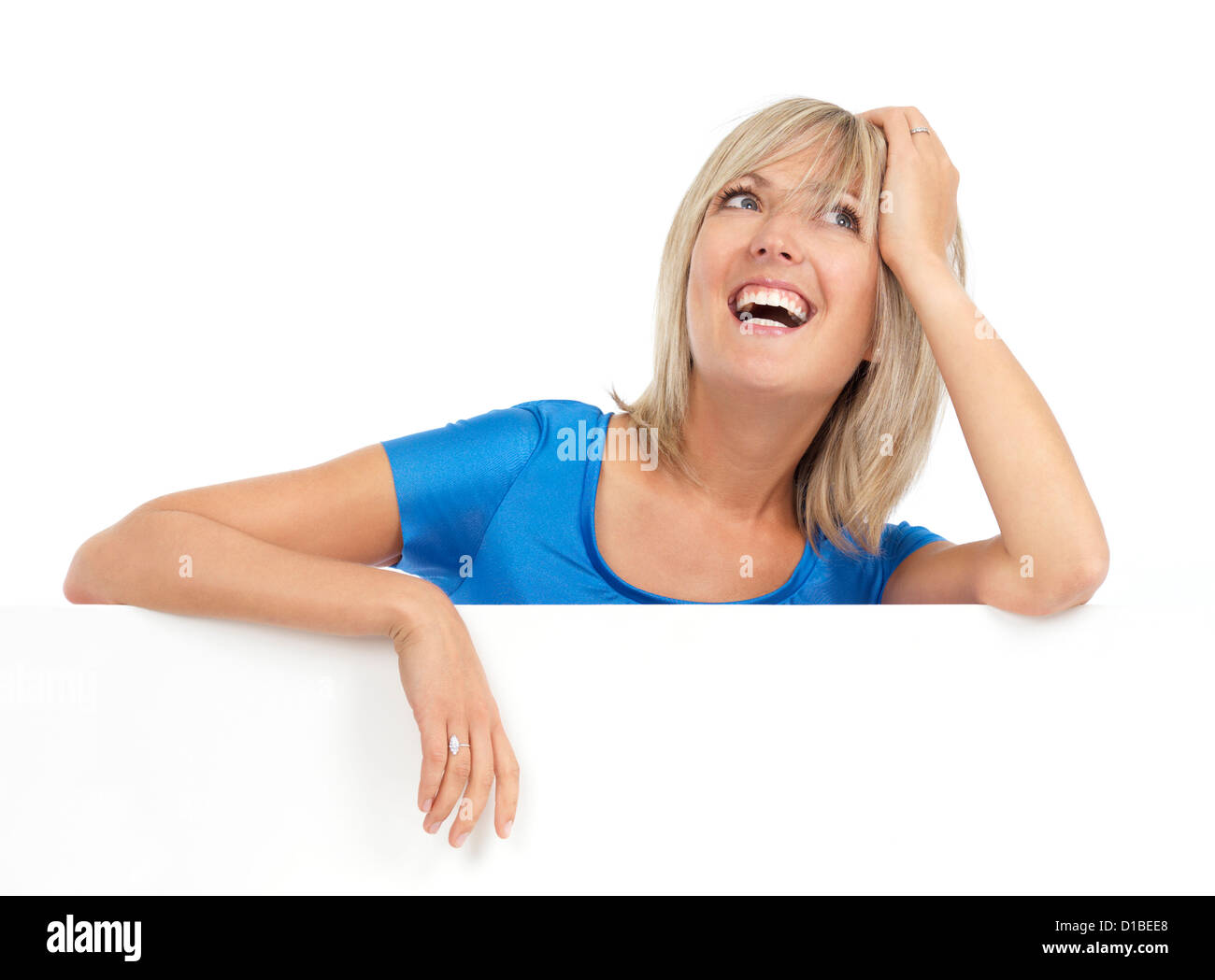 Portrait of a young smiling blond woman looking up with daydreaming expression. Isolated on white background. Stock Photo