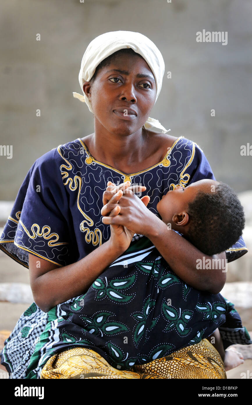 Mother with her sleeping son (fallen ill on Malaria) on a bench in a church in Bagamoyo, Tanzania Stock Photo