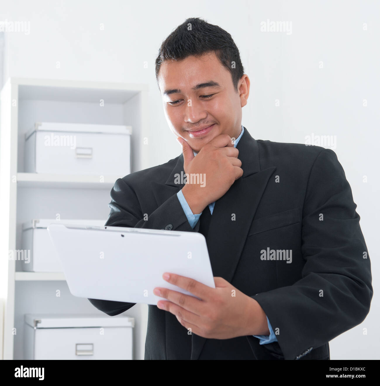 Southeast Asian people online ebusiness network, thought and looking on computer tab. Stock Photo