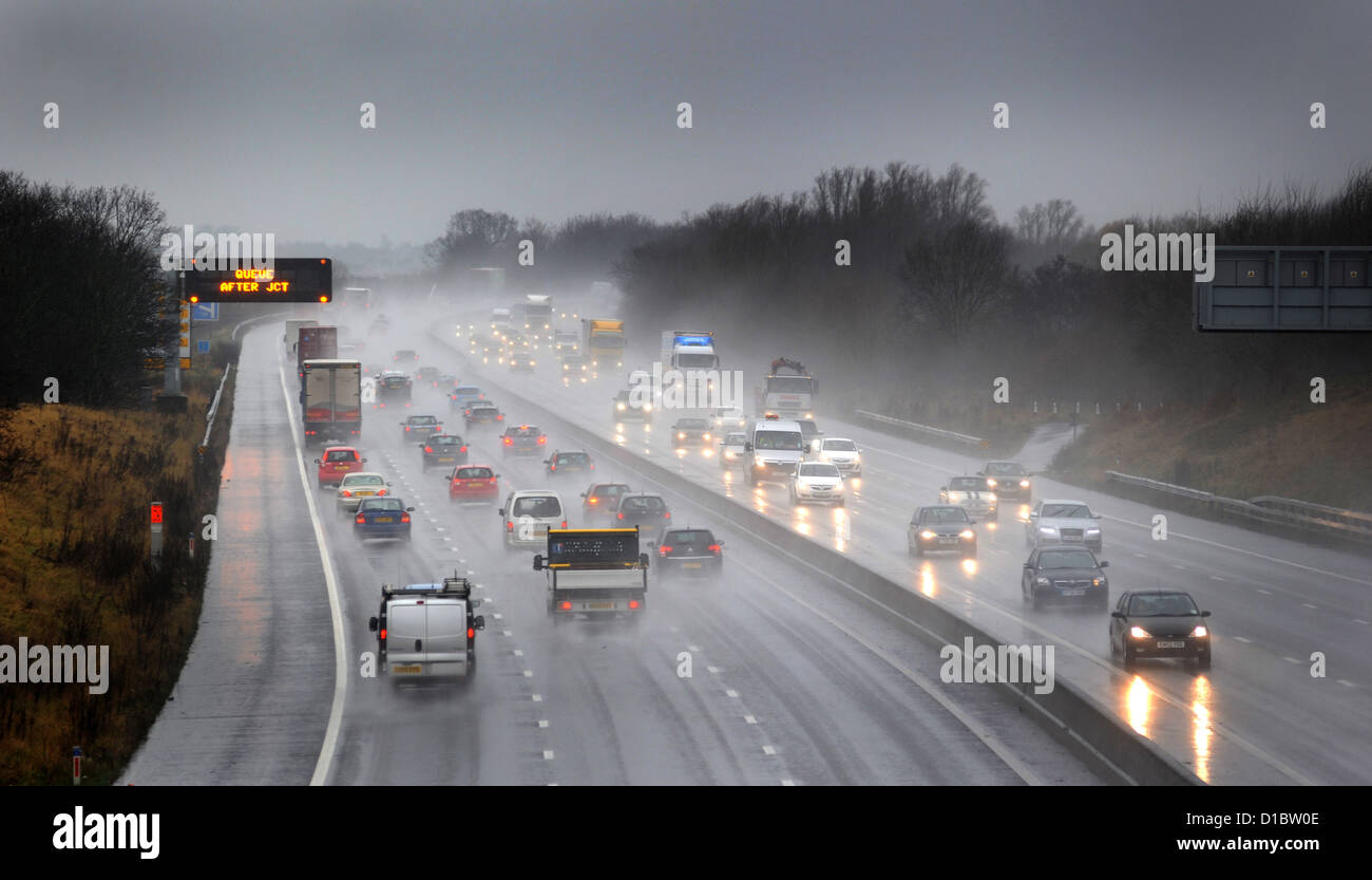 TRAFFIC TRAVELLING ON THE M6 MOTORWAY NEAR STAFFORD IN WET RAINY POOR LIGHT CONDITIONS RE ROAD SAFETY DRIVERS HEADLIGHTS JAMS UK Stock Photo