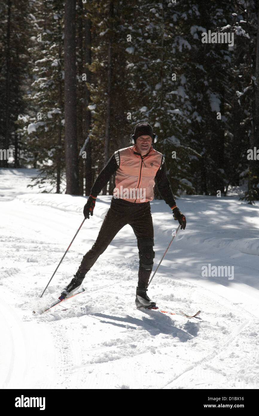 Skate skier zooms down a cross-country ski trail with snow falling around him as he goes. Stock Photo