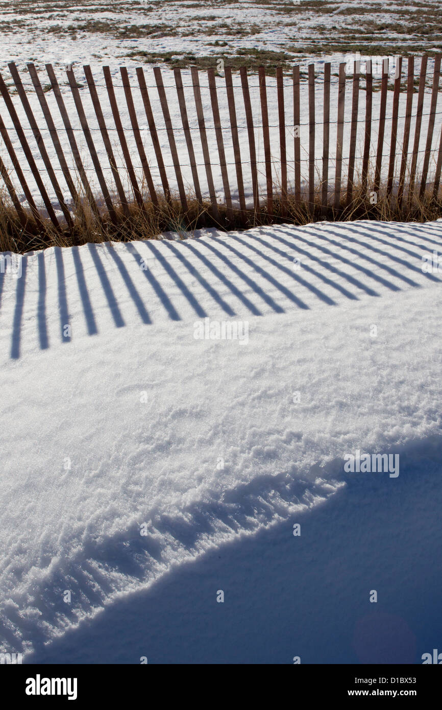 Snow drift behind snow fence. Stock Photo