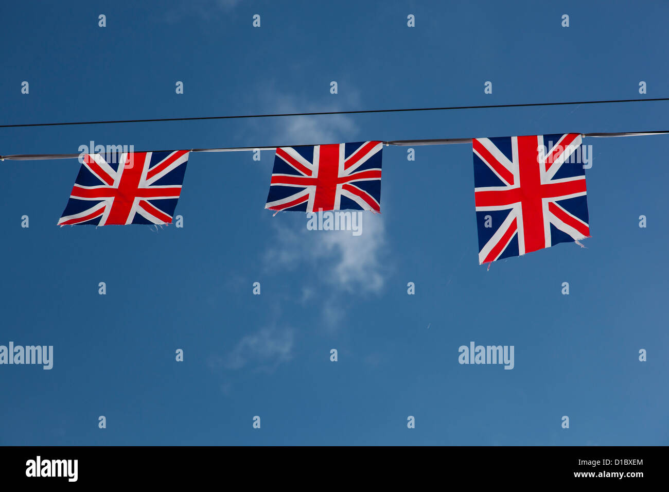 String of Union flags against a blue sky Stock Photo Alamy