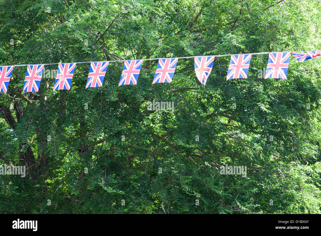 String of Union flags with trees behind Stock Photo Alamy