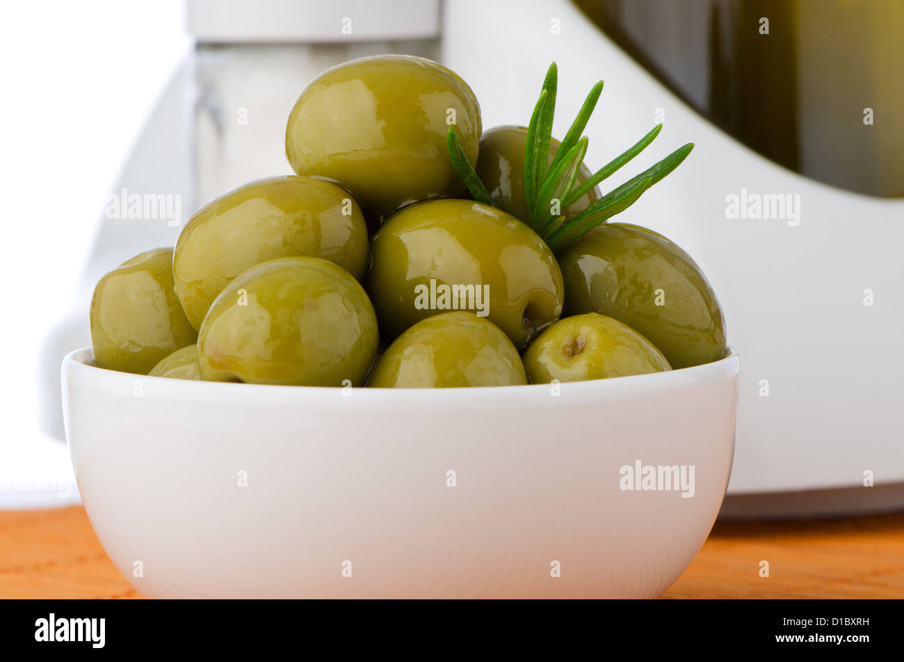 Green olives in a white ceramic bowl and oil decanter set Stock Photo ...