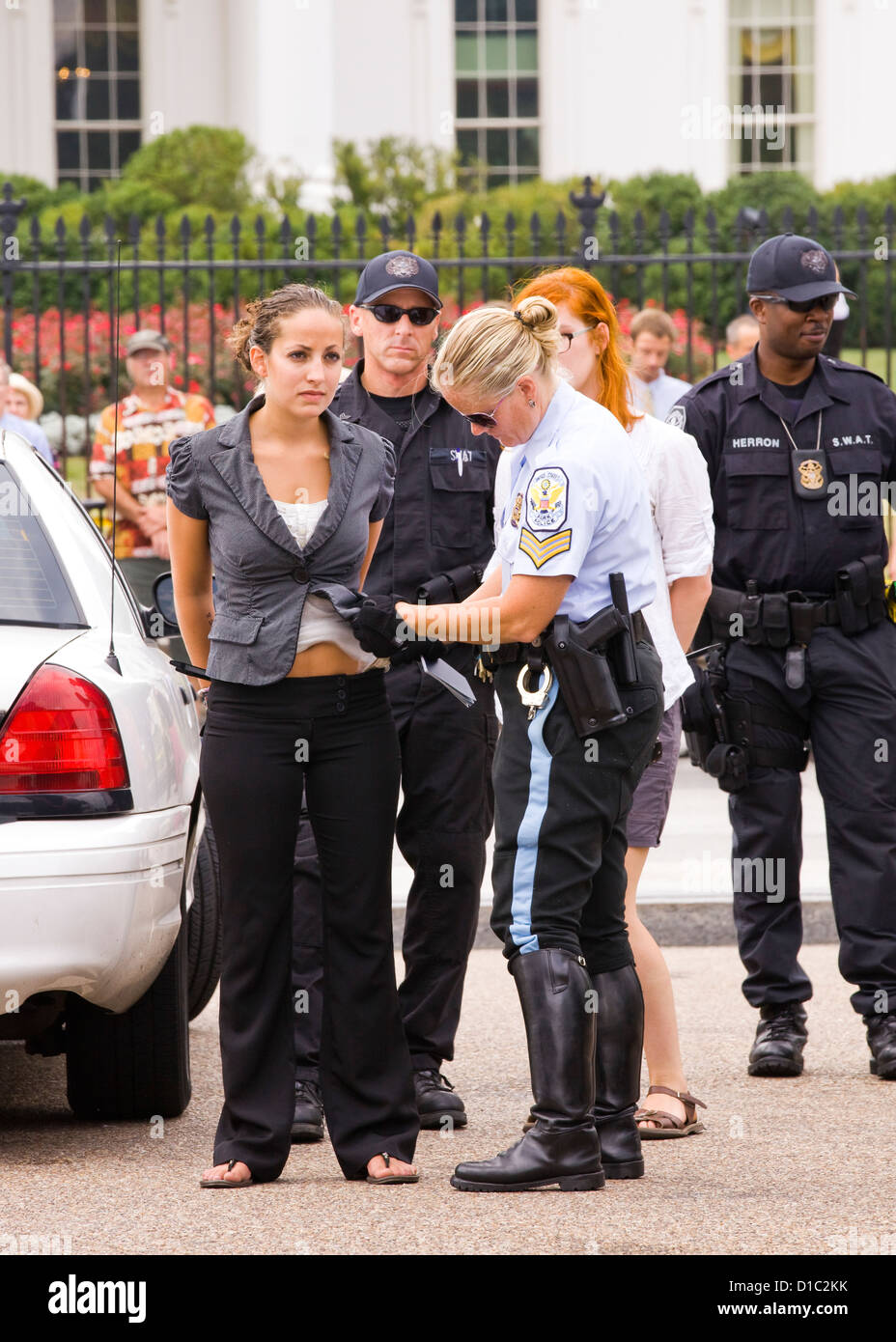 Woman under arrest and being searched by police at a public protest - Washington, DC USA Stock Photo