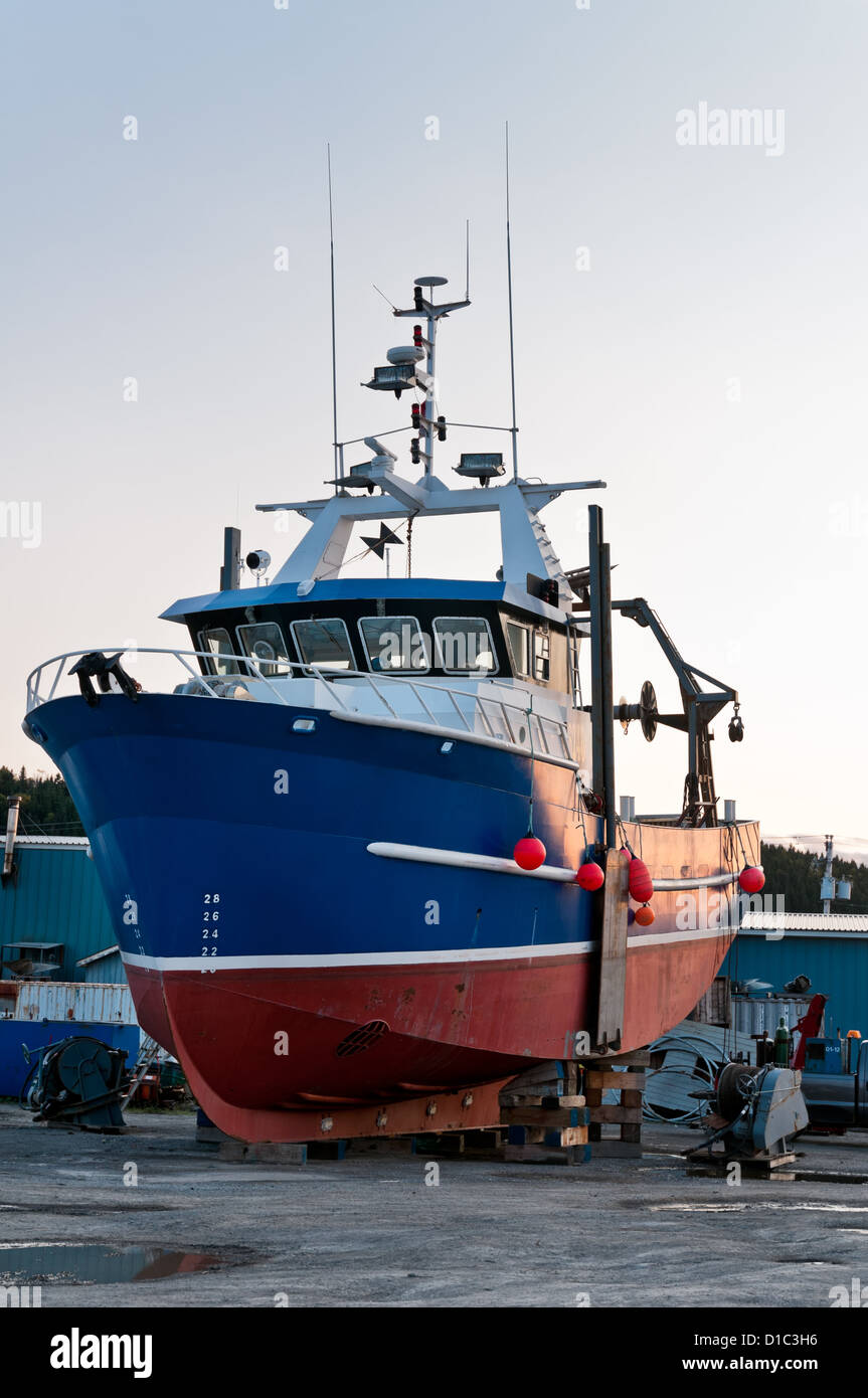 Fish trawler on land during off peak season, ship goes through maintenance Stock Photo