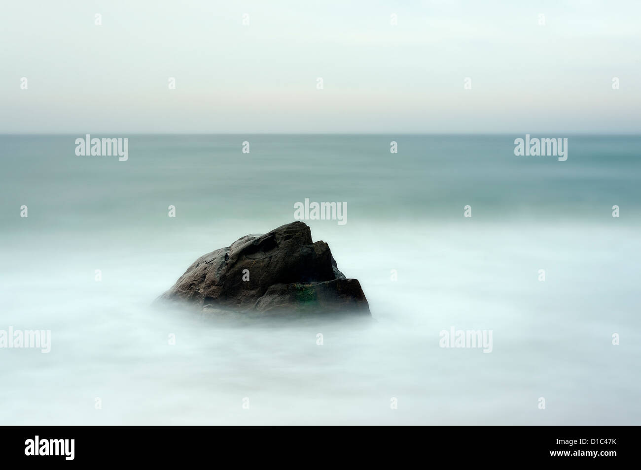 Rock with moving ocean water. Stock Photo