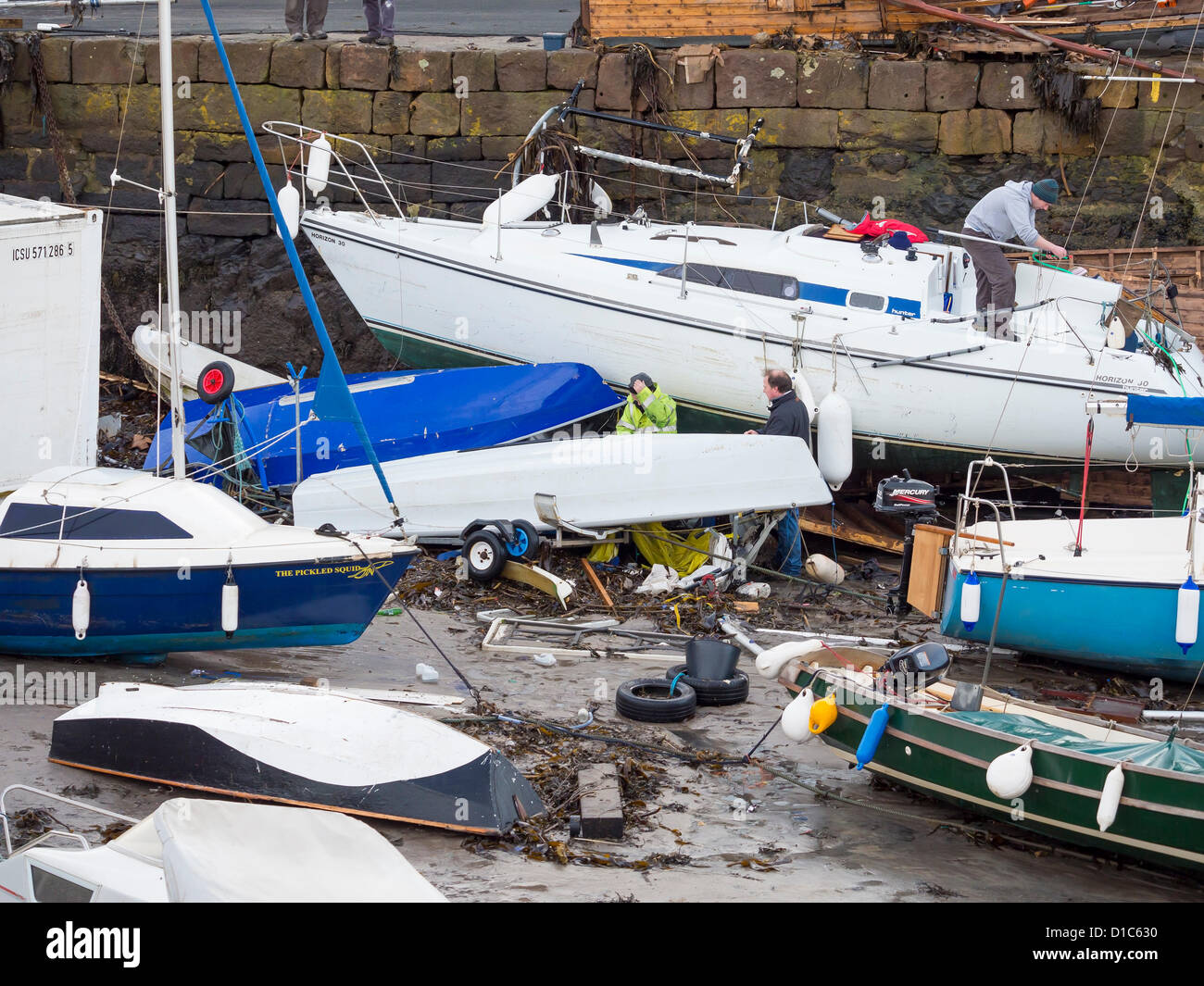 North Berwick, Scotland, UK. 15th December 2012. Storm damage in the old harbour of the fishing village. A major storm swept in overnight from the North Sea and 20 foot waves broke over the seawall, sending a 40 foot refrigerated container that was parked in the carpark into the harbour, smashing many boats and yachts, causing tens of thousands of pounds of damage. Luckily no one was hurt. Credit:  Bill Miller / Alamy Live News. Stock Photo