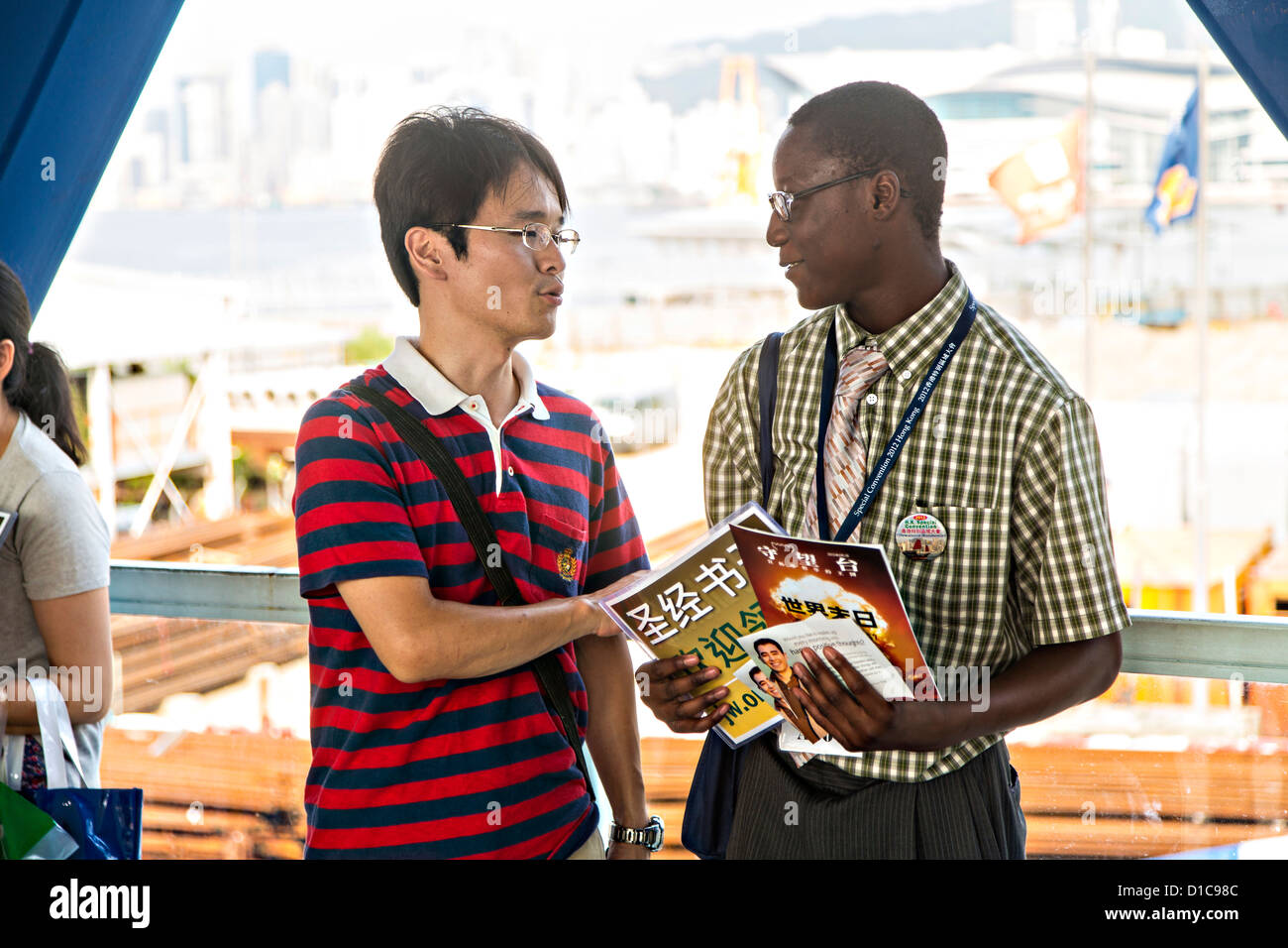 A Christian missionary proselytizes a local resident in Central District Hong Kong. Stock Photo