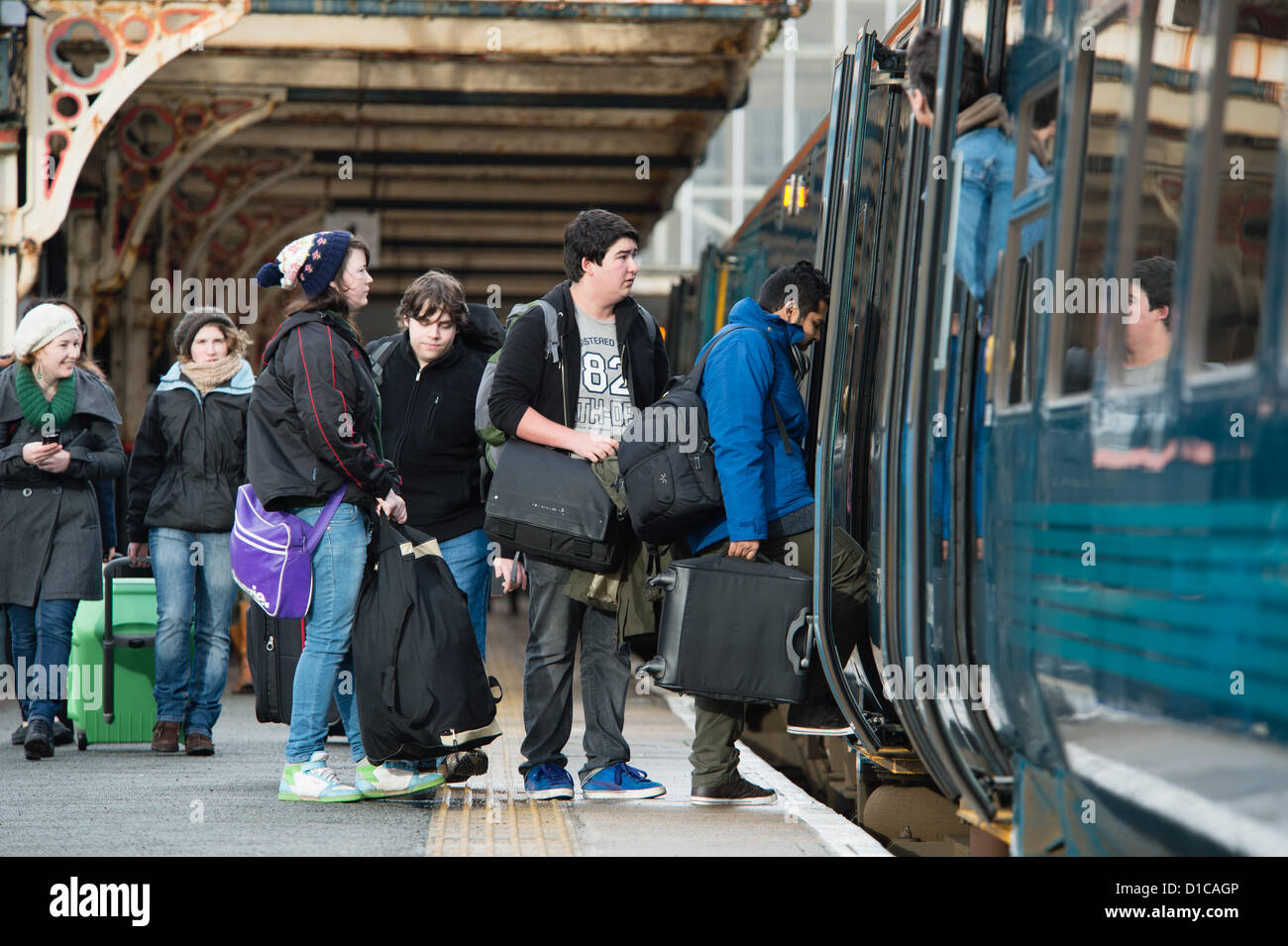 Aberystwyth, Wales, UK, December 15 2012:  Groups of young University and college students carrying bags of luggage catching the Arriva Wales train from Aberystwyth railway station at the end of term, going home to their families for the Christmas holiday vacation Stock Photo