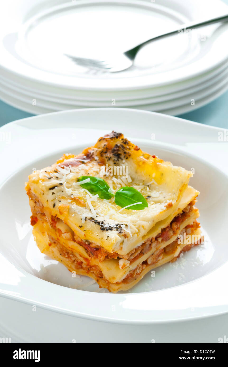 Portion of lasagna with meat topped with parmesan and basil Stock Photo