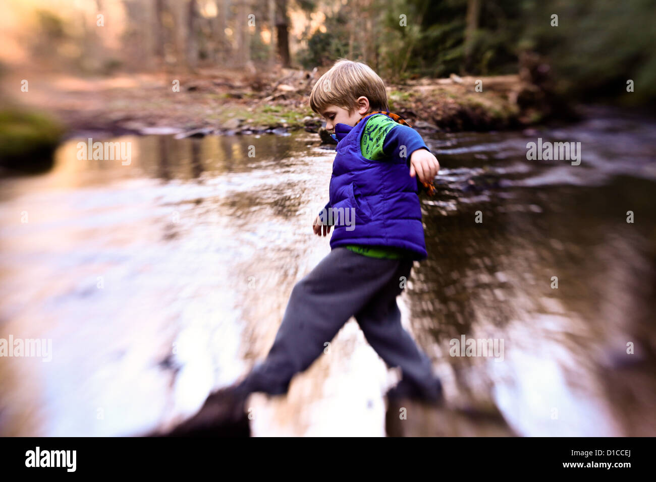 Little boy balancing himself between two rocks in a stream Stock Photo ...