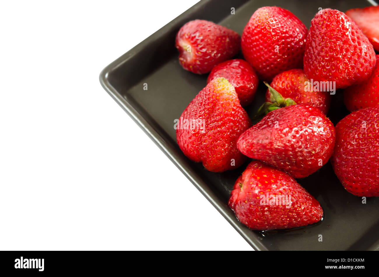 fresh strawberries on black dish over white background Stock Photo - Alamy