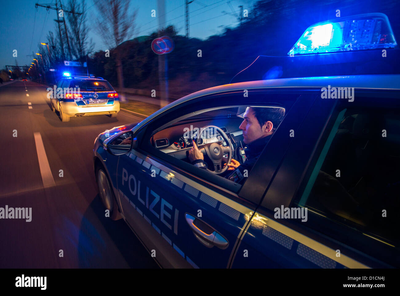 Police patrol car with blue flashing lights, signal horn, driving fast during an emergency mission. Stock Photo