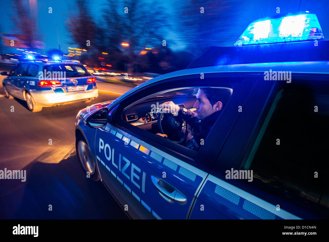 Police patrol car with blue flashing lights, signal horn, driving fast during an emergency mission. Stock Photo